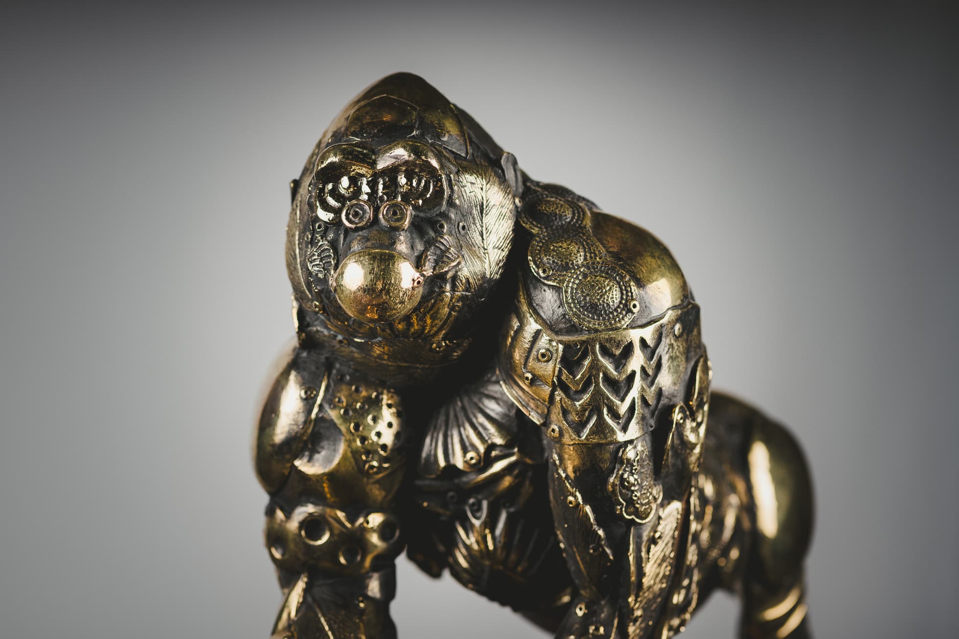 Escultura de gorila con elementos metálicos dorados