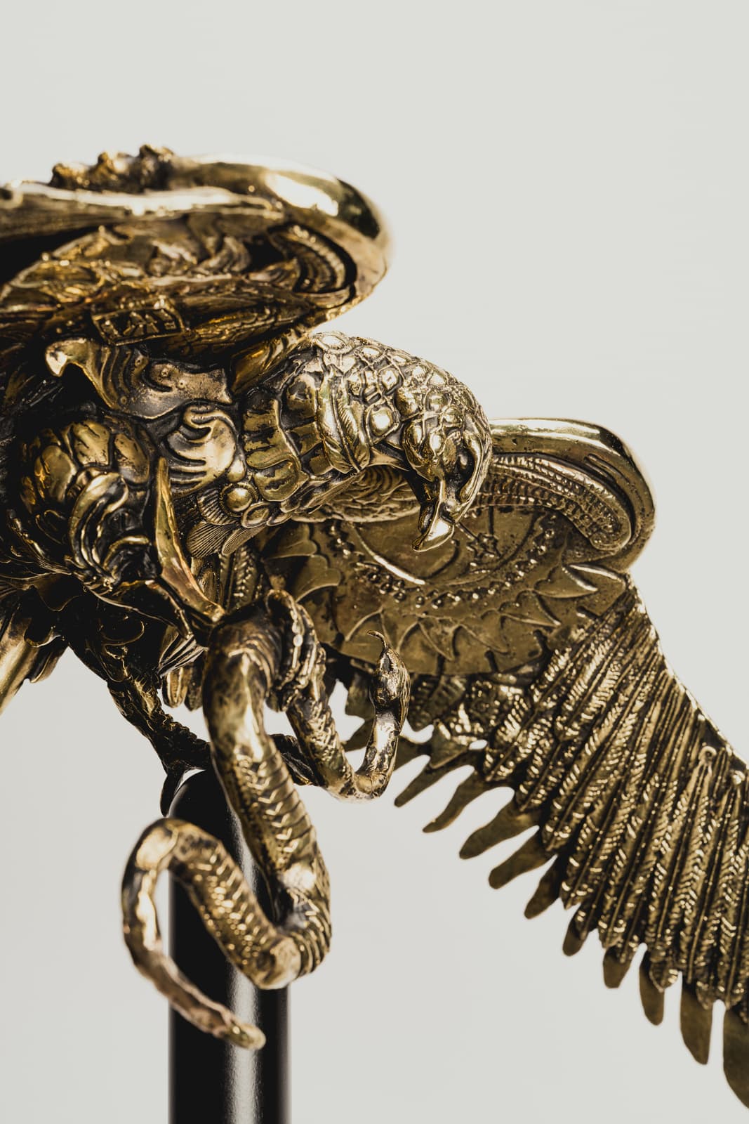 Escultura de ave con alas y elementos metálicos dorados