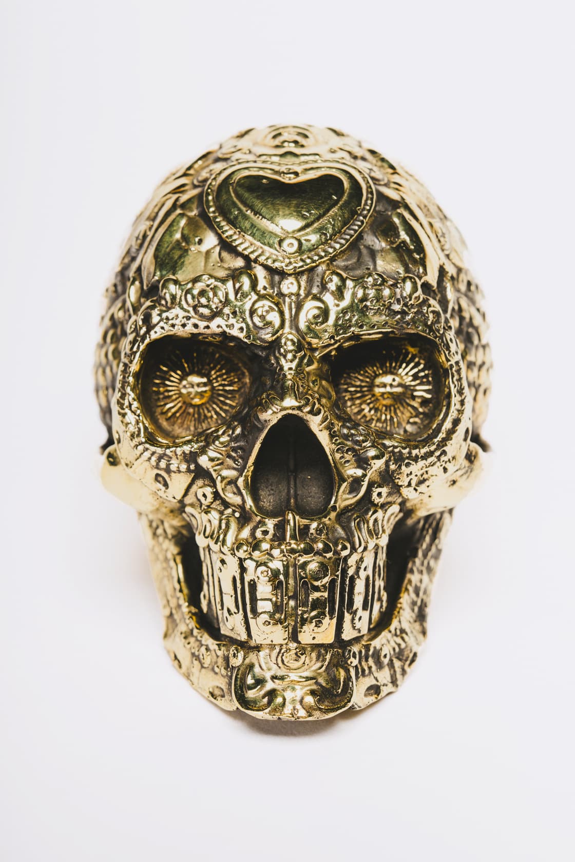 Escultura de cráneo con ornamentos dorados